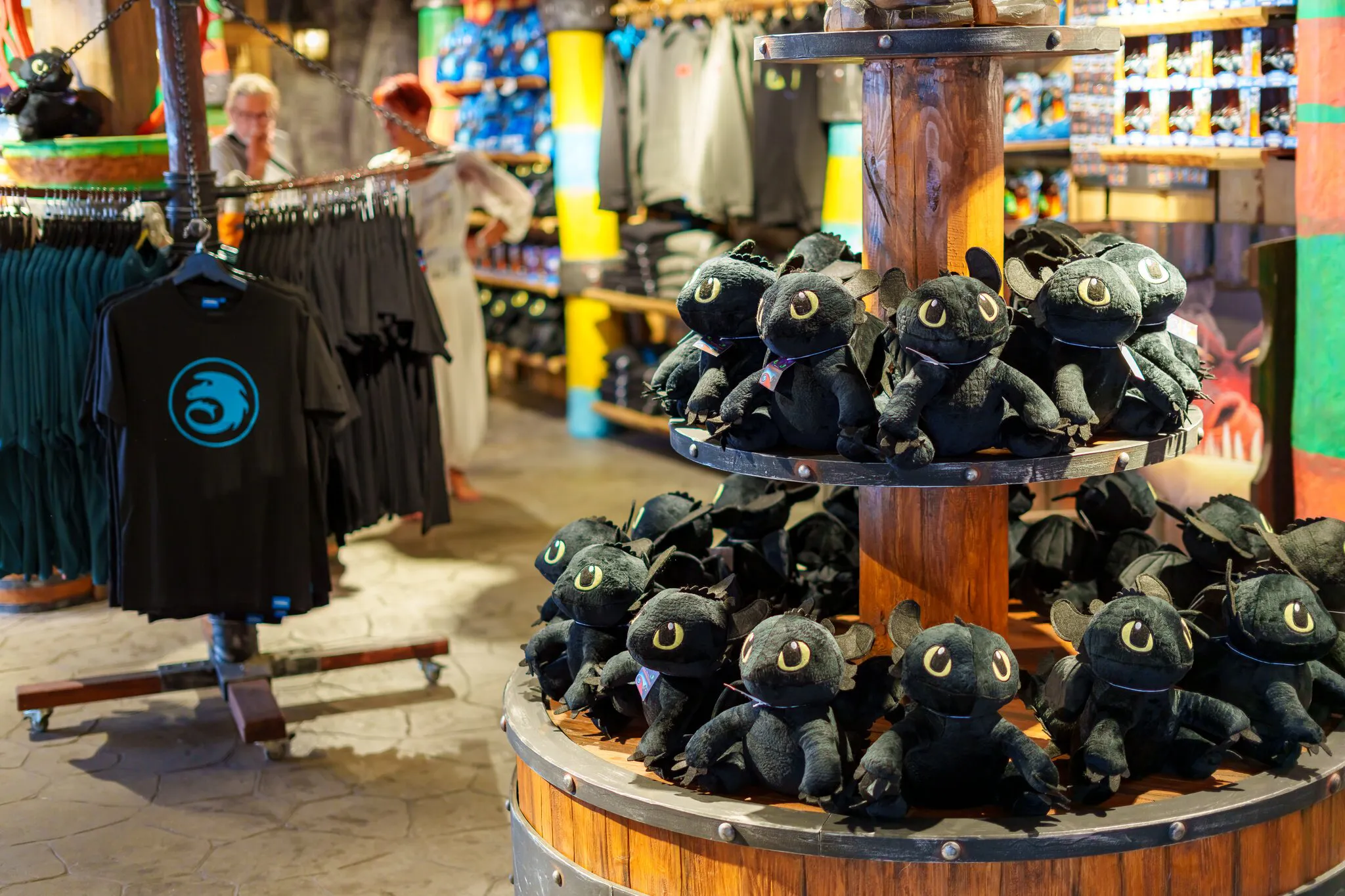 Blick in den Drachenzähmen-Shop im Heide Park Resort. Im Vordergrund sind Ohnezahn Plüschfiguren zu sehen und im Hintergrund T-Shirts.