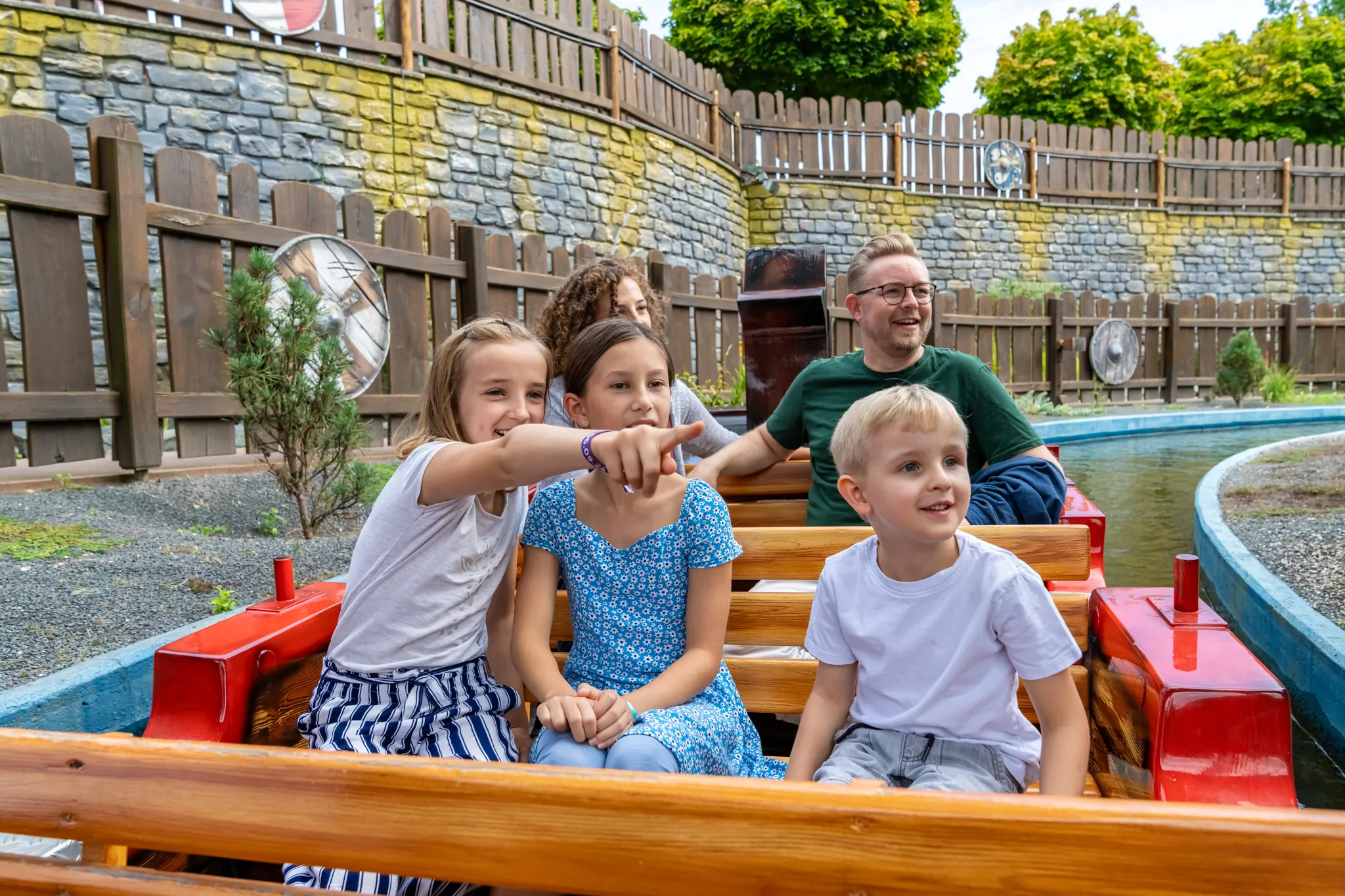 Eine Familie mit drei Kindern sitzen im Wikingerboot und erkunden die Attraktion 