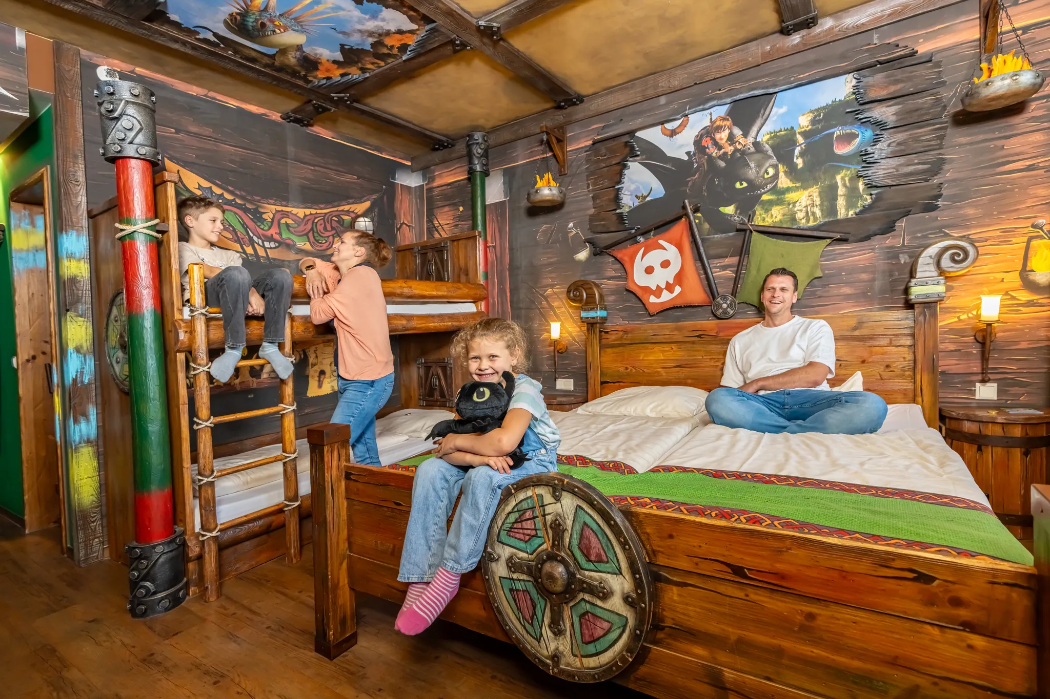 Eine vierköpfige Familie ist im Drachenzimmer bestehend aus Doppelbett und Stockbett. Die Thematisierung ist von Drachenzähmen leicht gemacht mit Drachen- und Wikinger-Elementen.